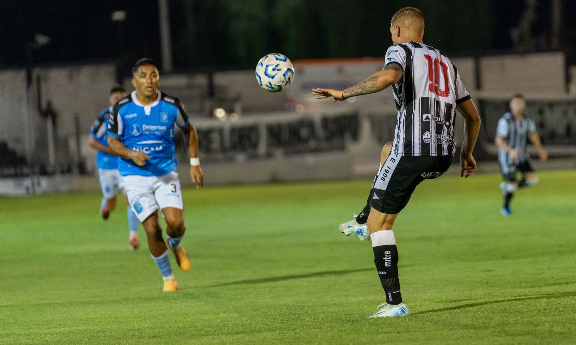 Footballers competing during an evening match