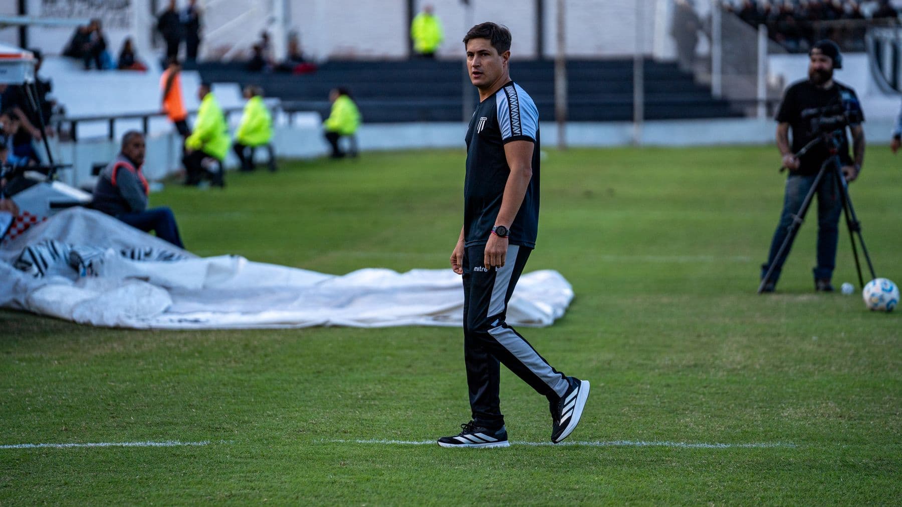 Football professional observing a match from the touchline