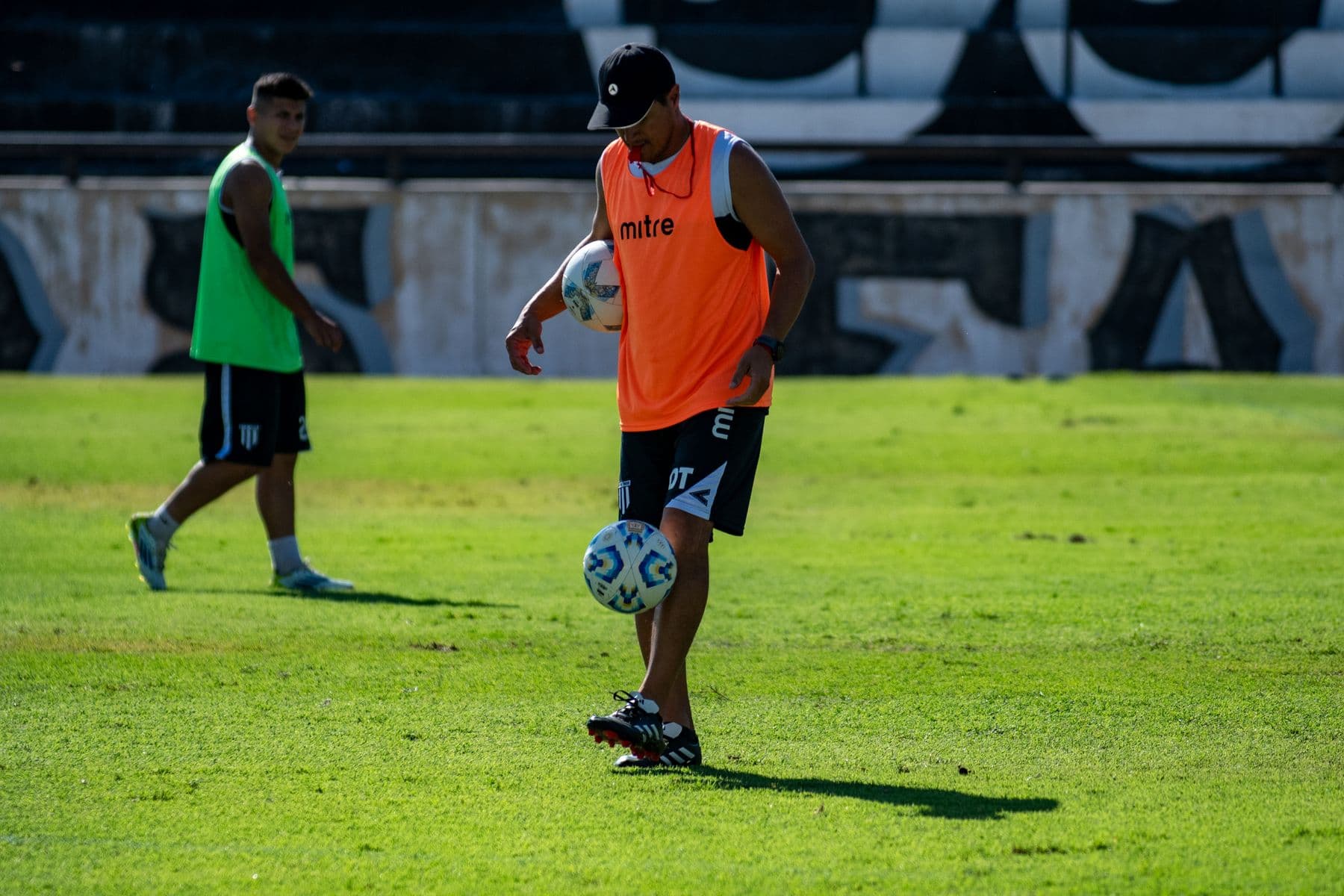 Two footballers training with a ball on a sunny field